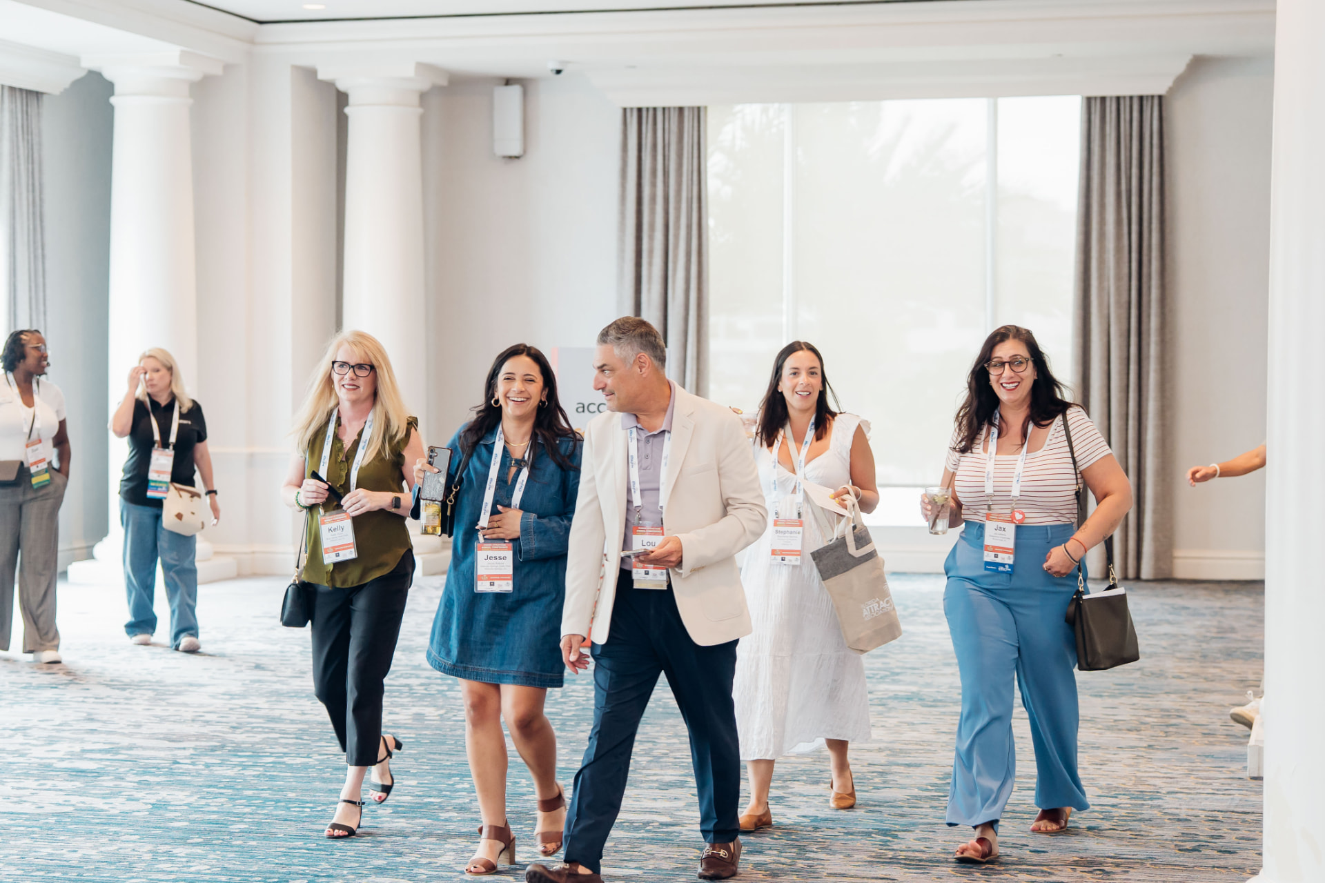 Corporate event photography of conference attendees walking through a hotel ballroom