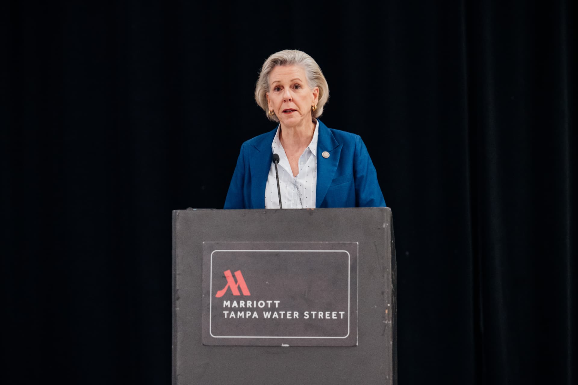 Corporate event photography of a leader speaking at a podium at the Marriott Tampa Water Street