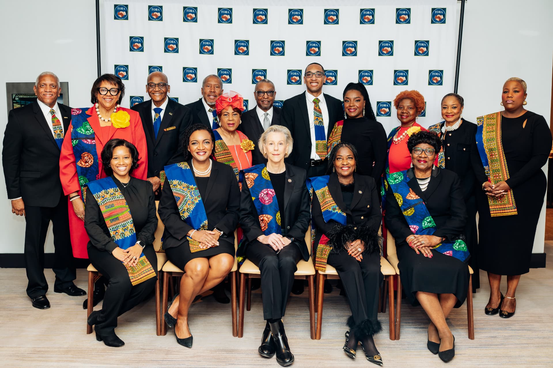 Corporate event photography of a formal group portrait in front of a TOBA step-and-repeat backdrop at a Tampa leadership breakfast