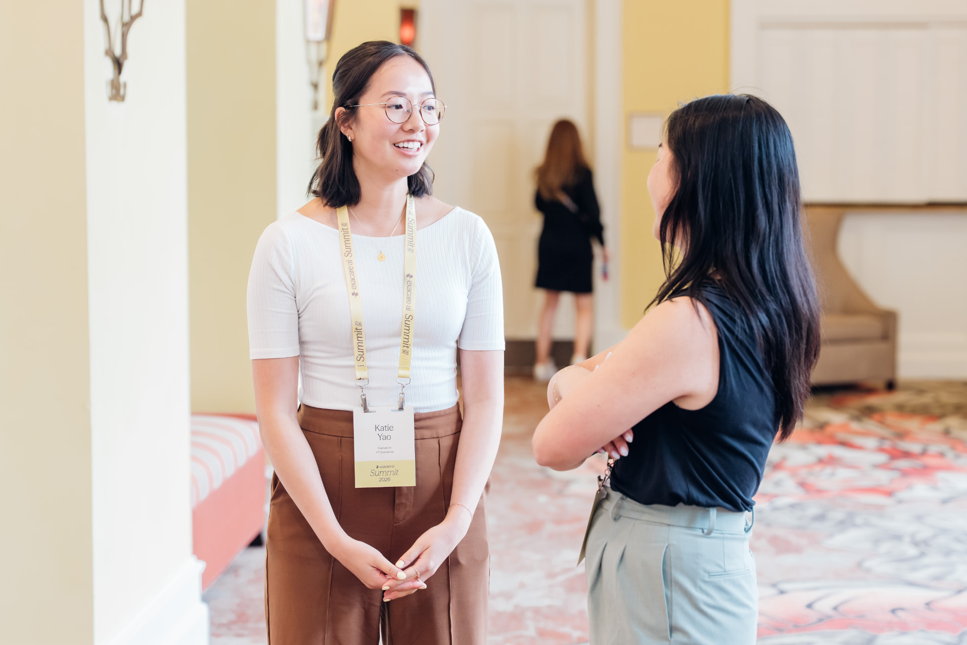 Corporate event photography of two colleagues in conversation in a hotel corridor during a summit