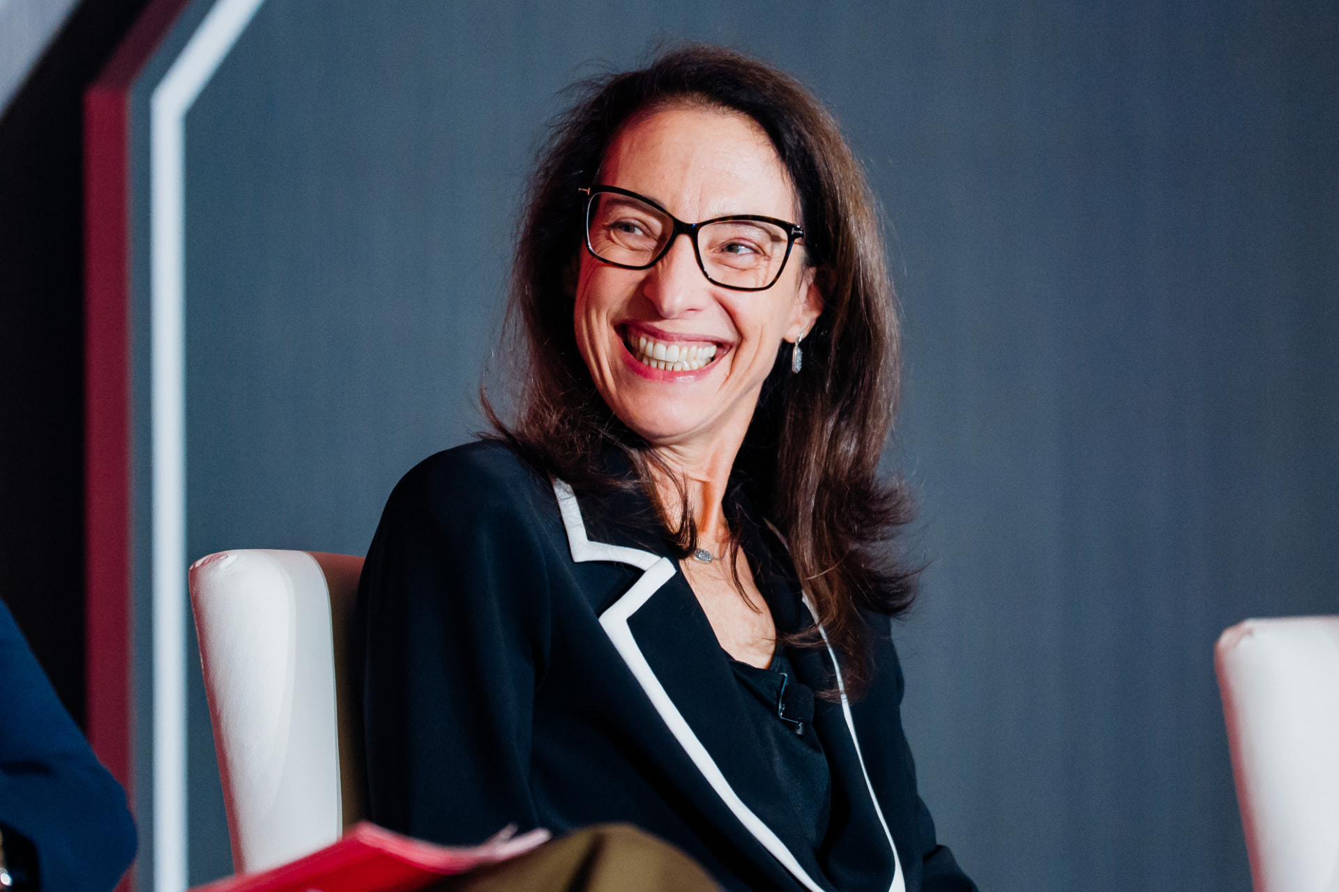 Corporate event photography portrait of a panelist laughing on stage in Miami
