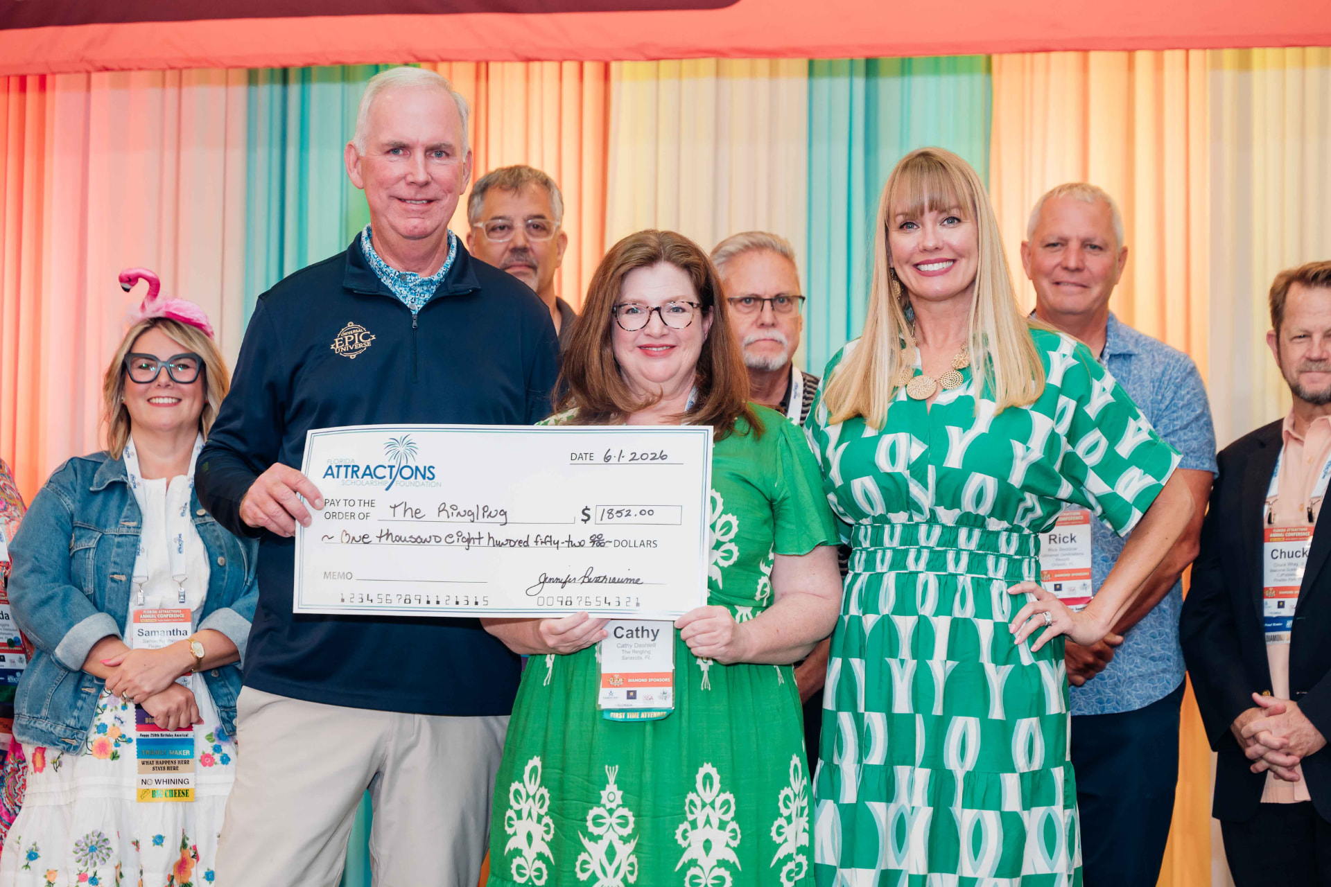 Corporate event photography of a group holding an oversized ceremonial check at an awards presentation