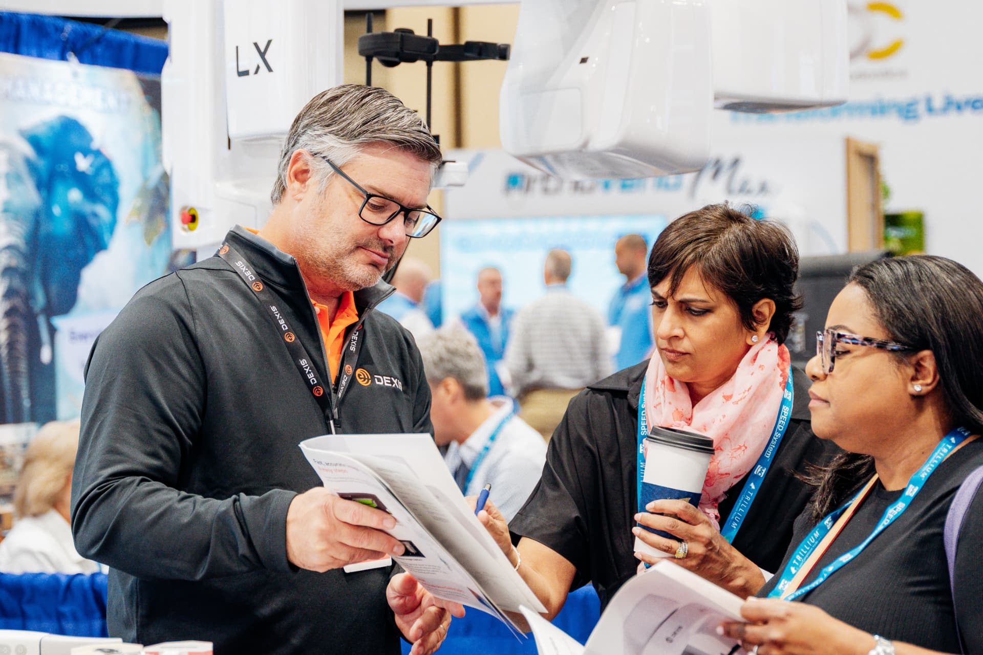 Corporate professionals reviewing materials together at an Orlando trade show booth during a conference