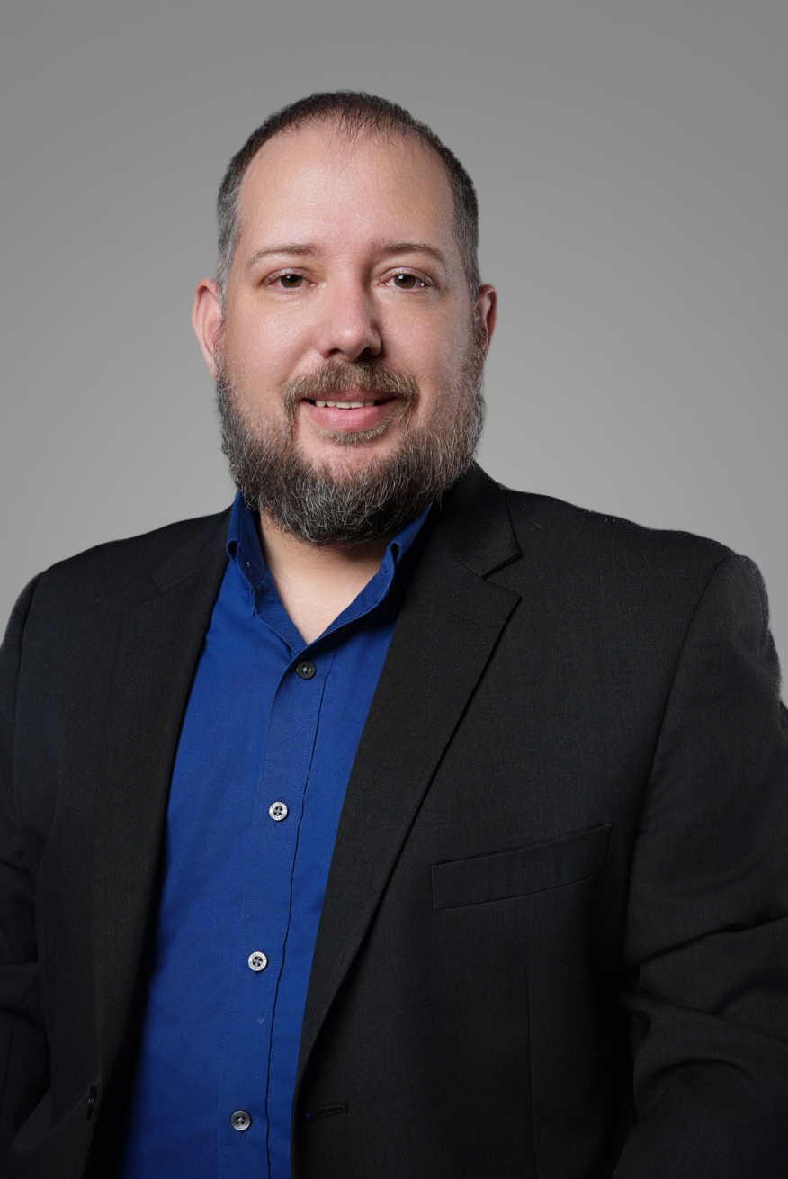 Corporate headshot of a man in a black blazer and blue shirt photographed at an on-site office headshot session — Endless Visuals Tampa executive headshots
