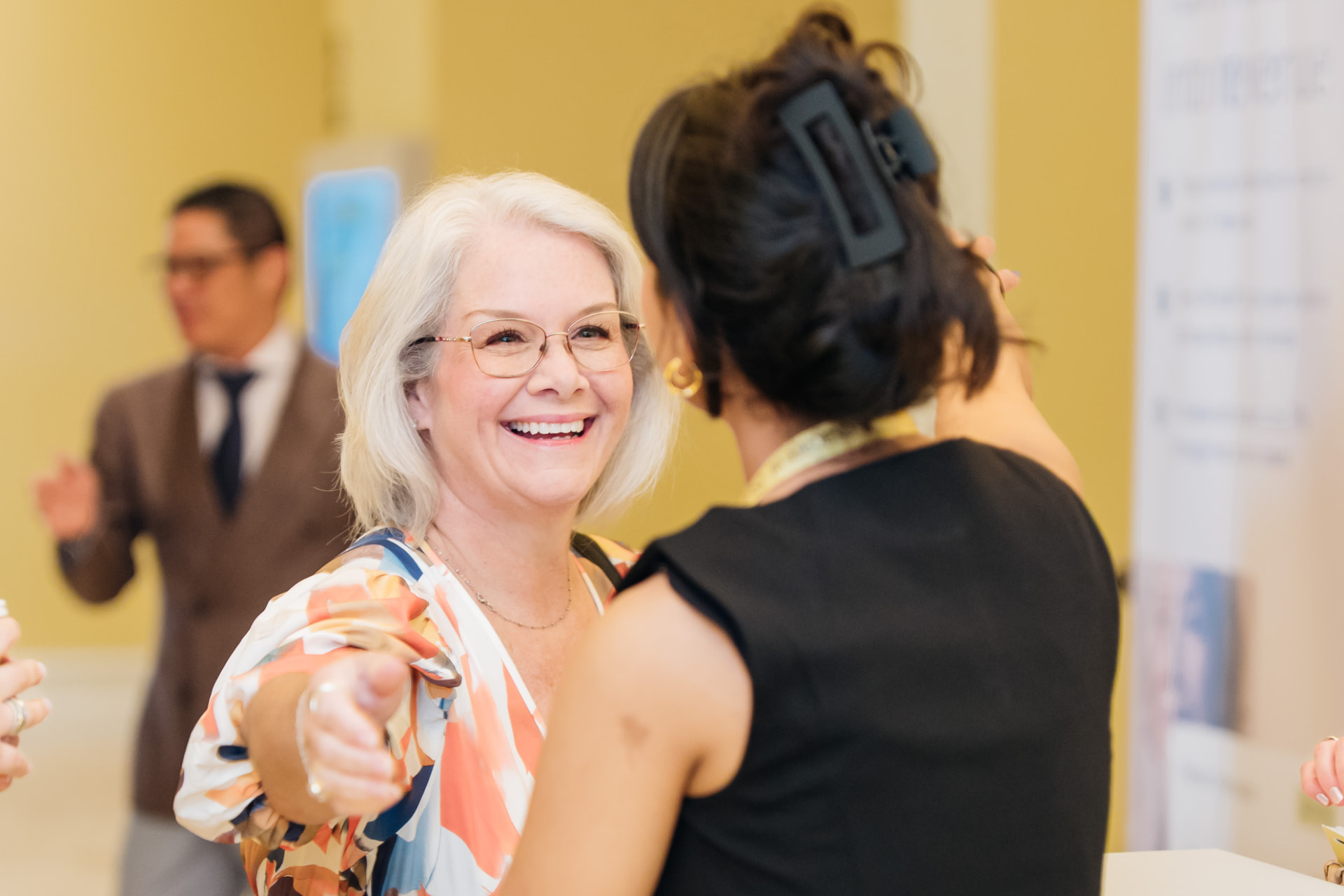 Corporate event photography of executives greeting at a Miami business summit