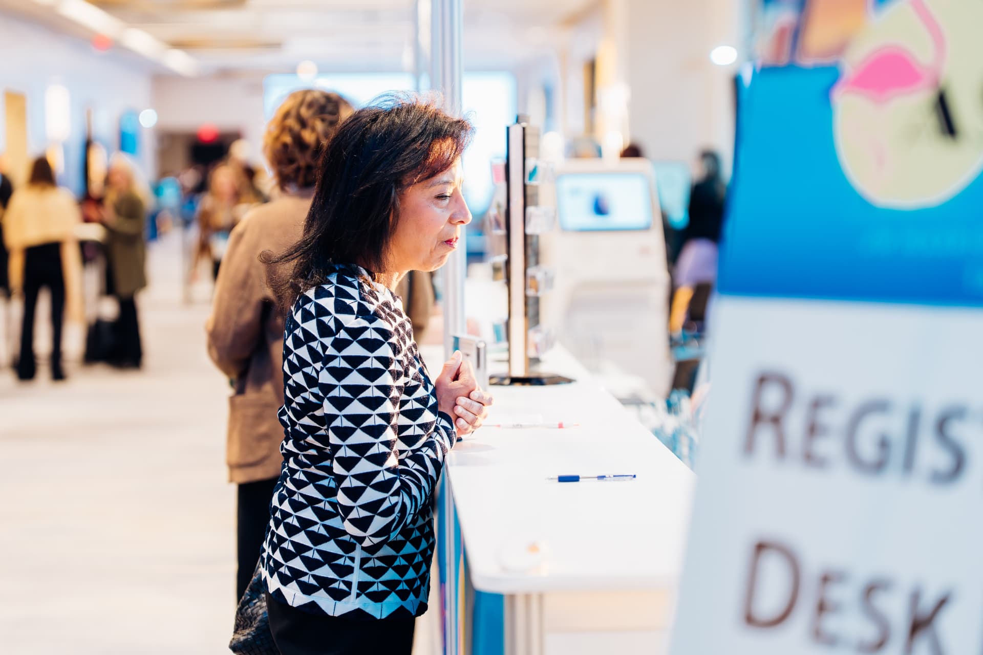 Corporate event photography of an attendee at the conference registration desk