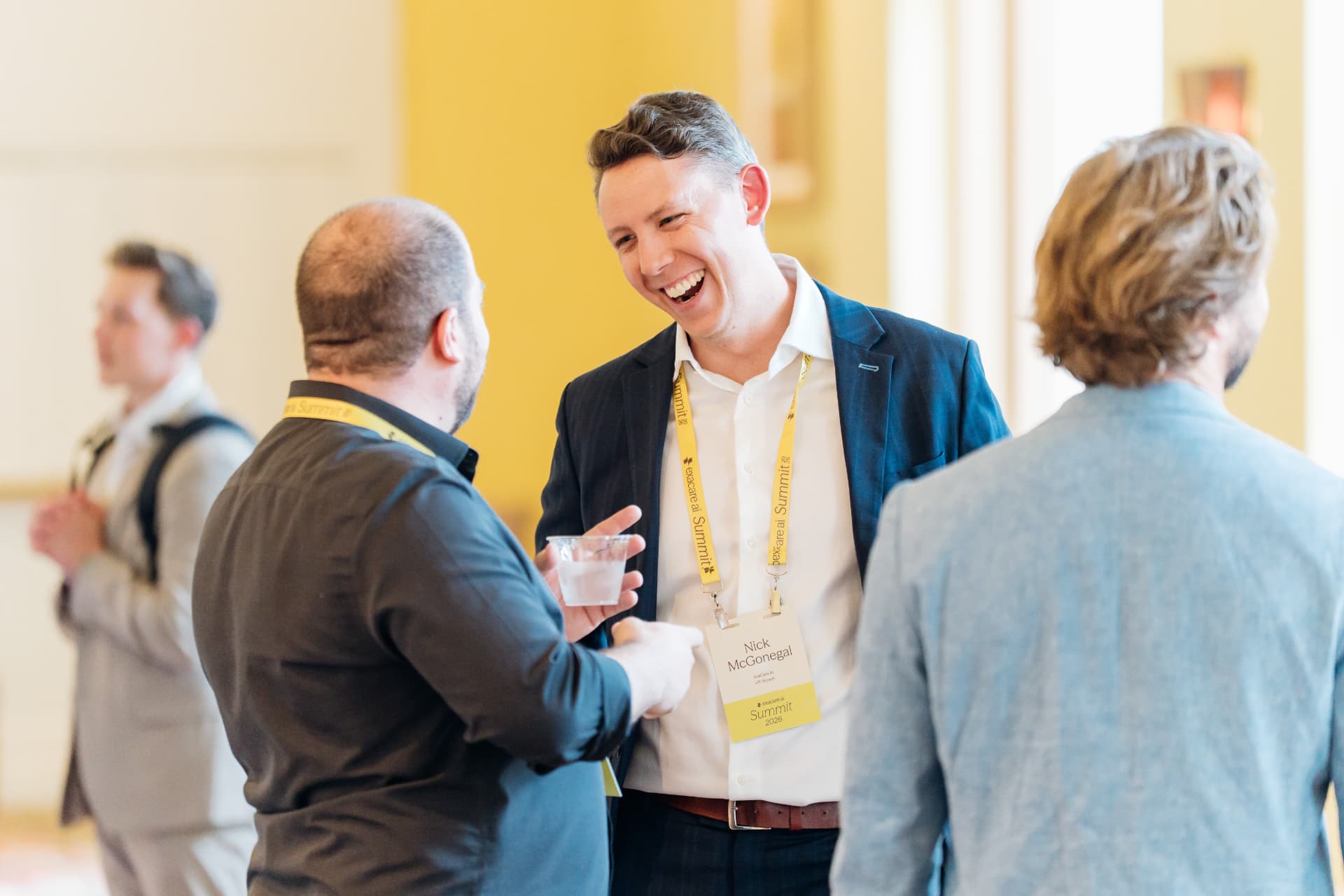 Corporate event photography of attendees laughing during a networking break at a summit