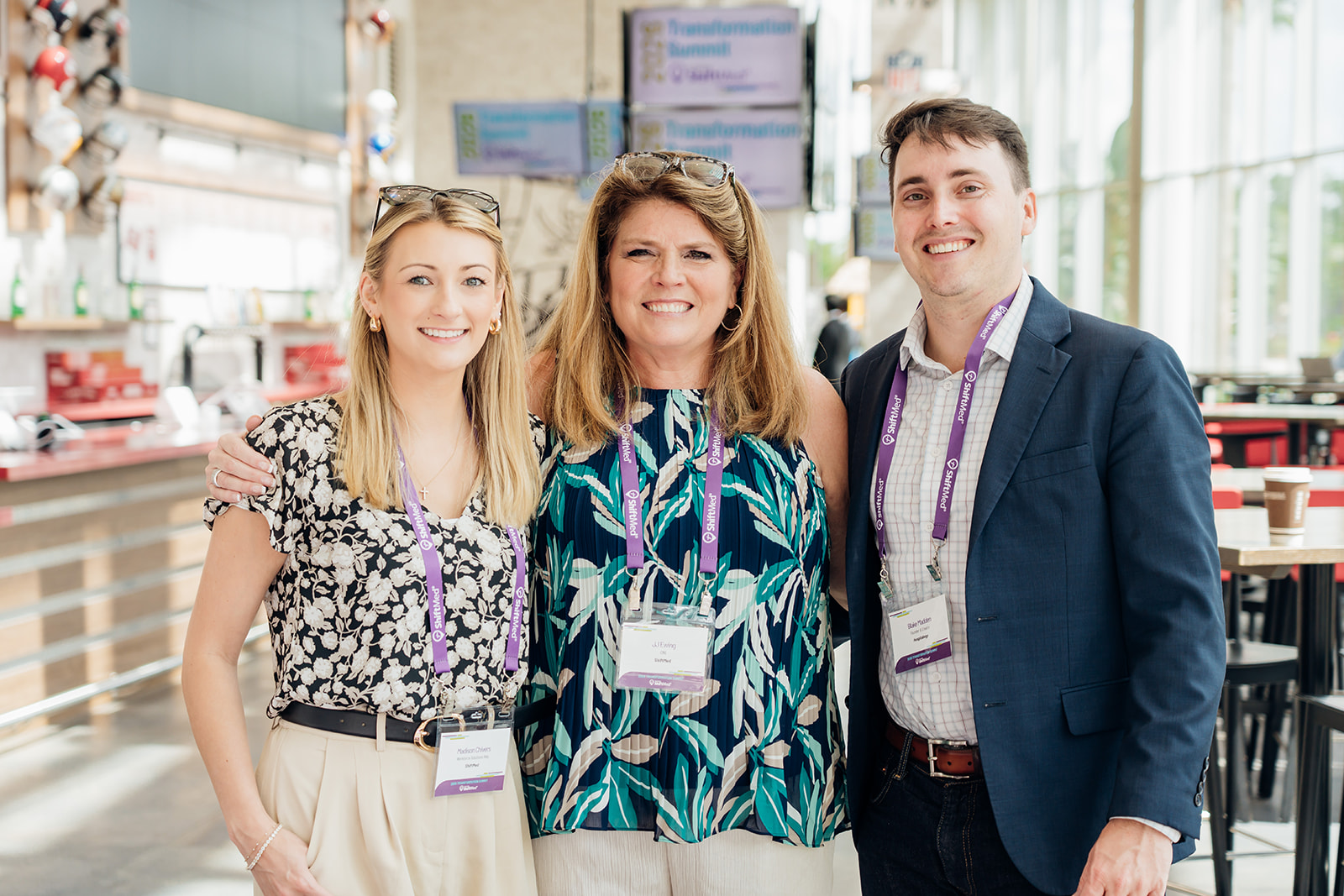 Corporate photography of three colleagues posing together at a transformation summit
