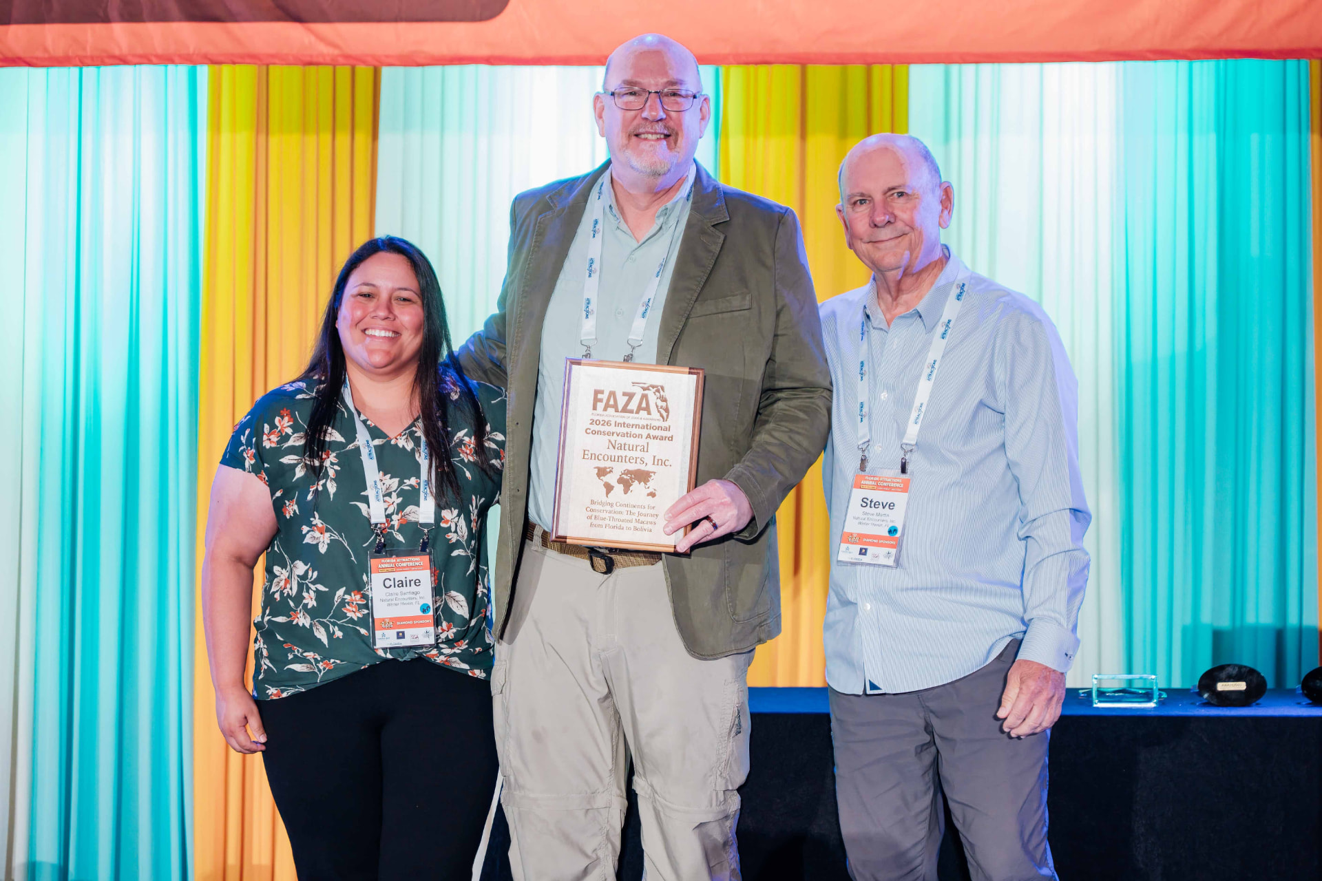Corporate event photography of an International Conservation Award plaque presentation on stage at a Florida attractions conference